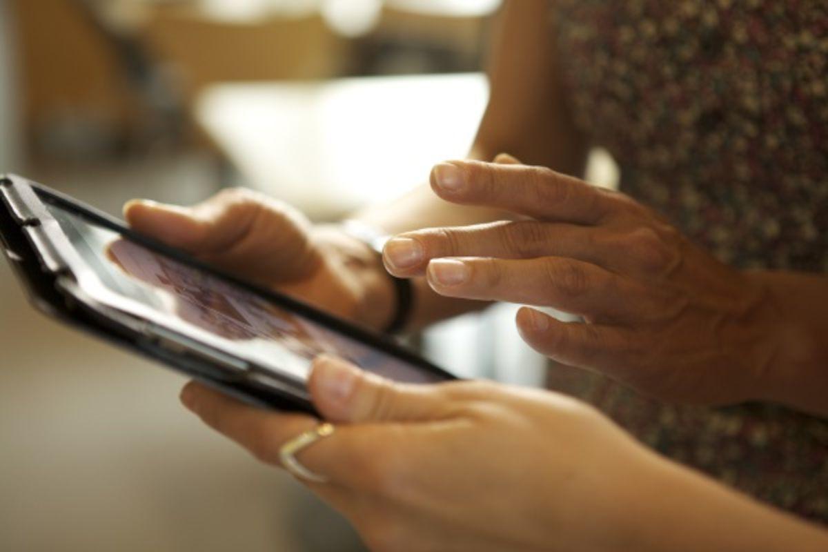 Two people using tablet for patient education.